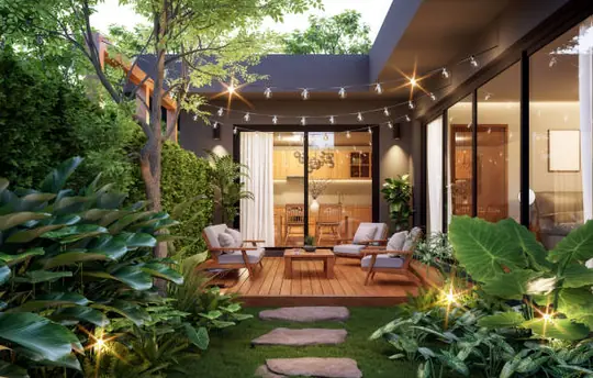 Terraza reformada con tarima de madera, mobiliario lounge e iluminación nocturna con guirnaldas