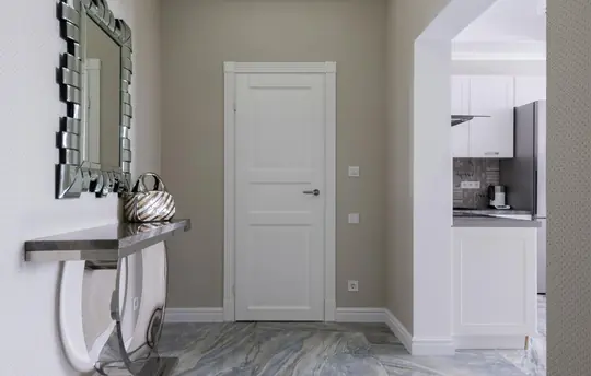 Passadís distribuïdor reformat amb terra laminat i fusteria lacada en blanc