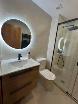 Moble lavabo de fusta amb espill rodó LED