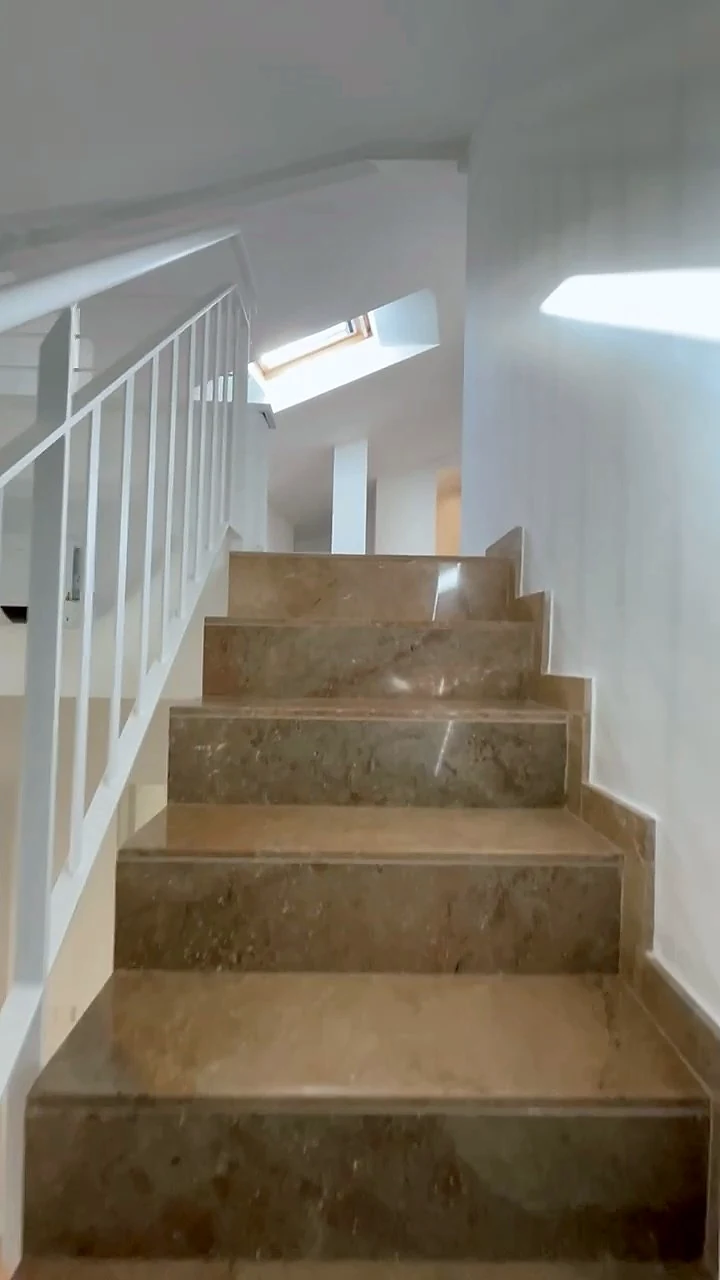 Escala del dúplex amb barana blanca que puja a les golfes