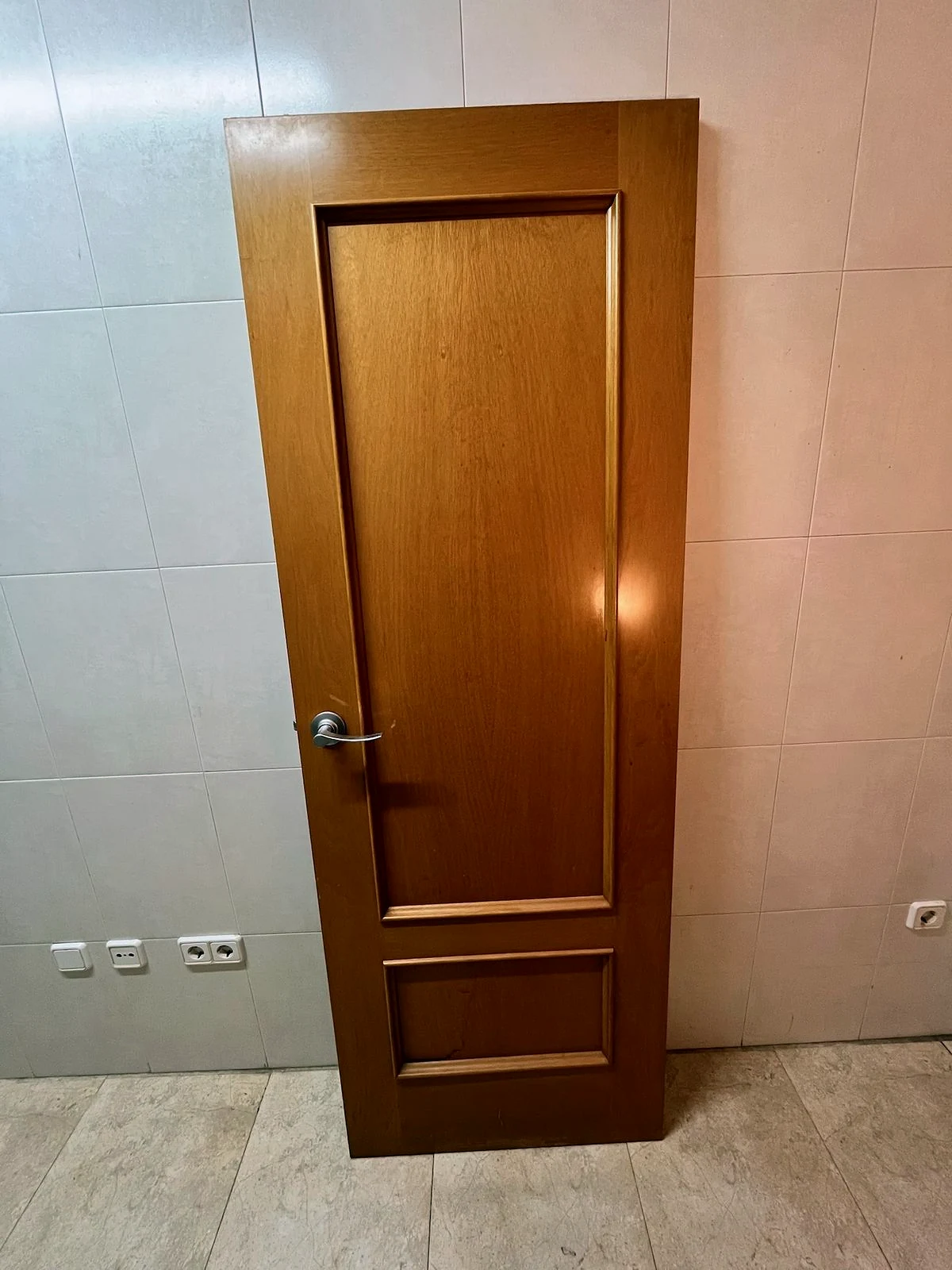 Porta de fusta envernissada en to mel abans de la reforma del pis a Fornells de la Selva