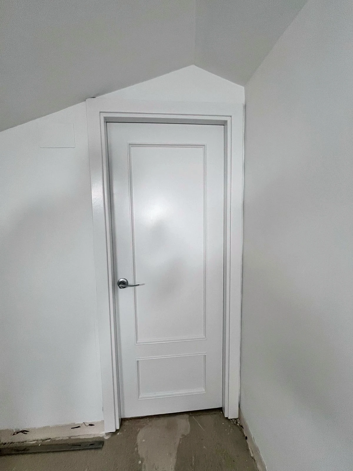 Porta lacada en blanc amb marc a joc després de la reforma del pis a Fornells de la Selva